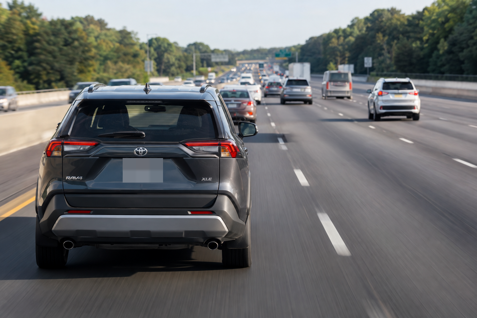 Vehicle traveling in the left lane while faster traffic approaches from behind on a multi-lane highway